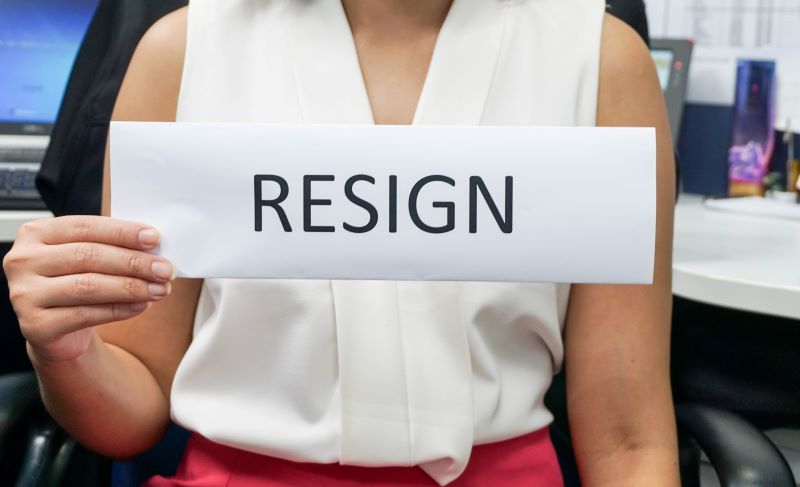 woman holding resign sign