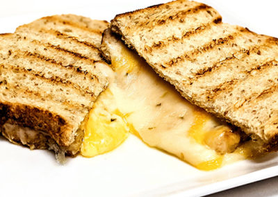 a grilled cheese, the Melter Skelter, on a plate from a Pacific Perks mobile food bar