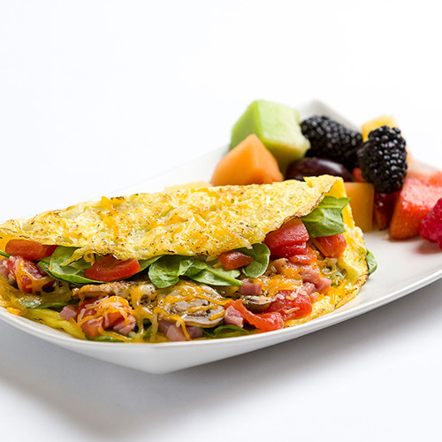 an omelet on a plate with berries from a Pacific Perks mobile food bar
