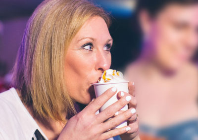 a woman sipping coffee with whipped cream from a Pacific Perks espresso mobile café