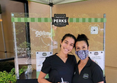 two Perkologists at an outdoor Pacific Perks ice cream sundae mobile café at a Columbia Credit Union event