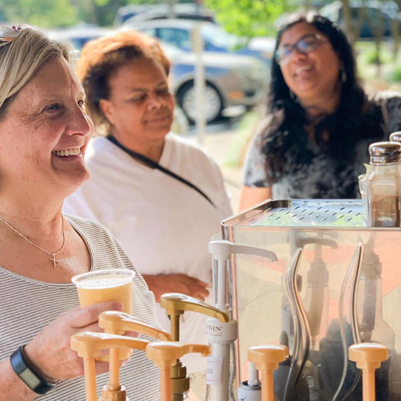 a group getting coffee drinks at an outdoor Pacific Perks espresso mobile café