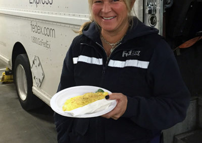 a Fed Ex teammate smiling with the Pacific Perks omelet plate
