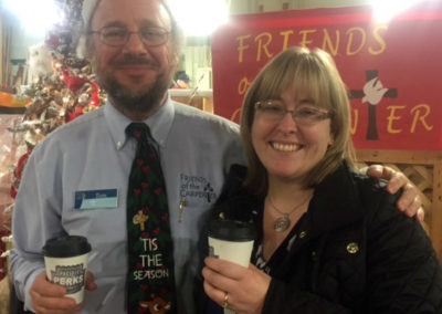 two people smiling with their coffee drinks from a Pacific Perks espresso mobile café during a Friends of the Carpenter Christmas event