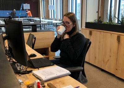 a PAE team member sips their Pacific Perks espresso drink at their desk