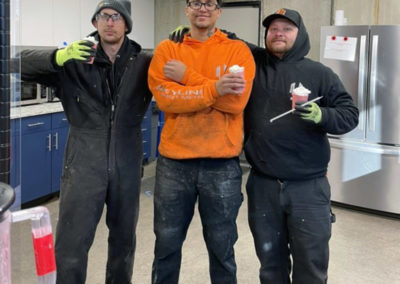 three Skyline Sheet Metal teammates posing with their coffee drinks during an event hosted with a Pacific Perks mobile café