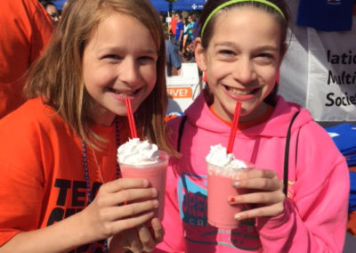 two children smiling with their smoothies from a Pacific Perks mobile café