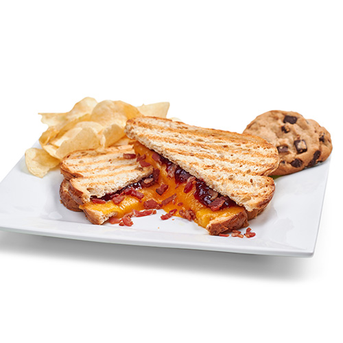 a plated "Bohemian Raspberry" grilled cheese sandwich with chips and a cookie from Pacific Perks