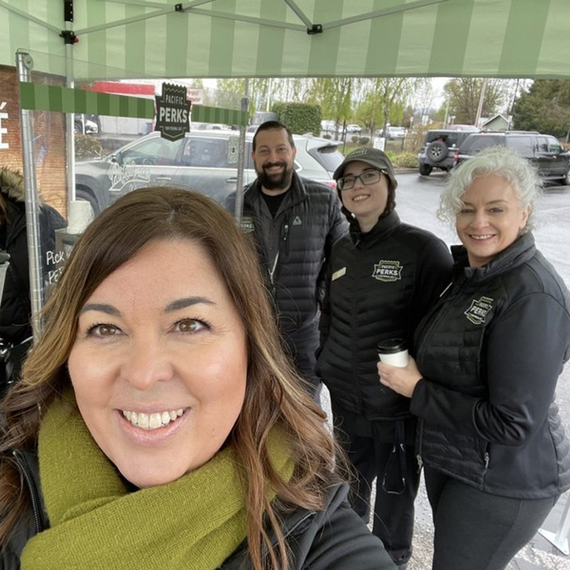 Natalie Fairchild taking a selfie with a Pacific Perks crew at an outdoor event at Riverview Bank