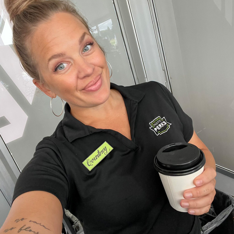 Perkologist Courtney taking a selfie while holding a coffee from a Pacific Perks espresso mobile café