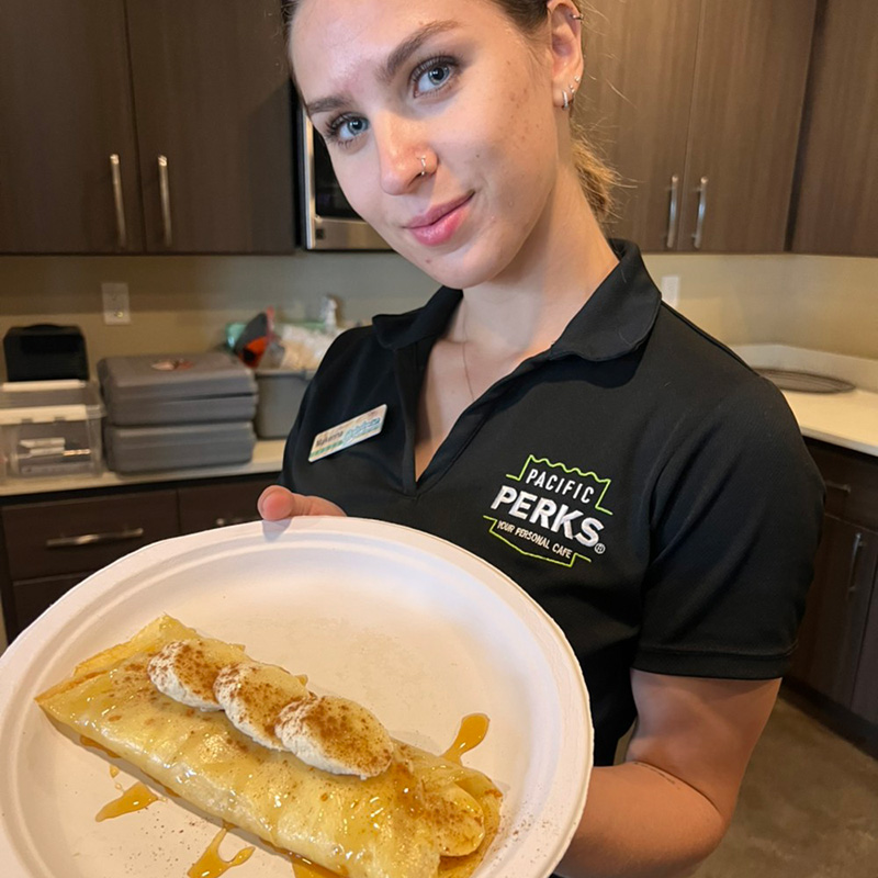 a Perkologist holding a plated crepe at an event hosted with a Pacific Perks mobile café