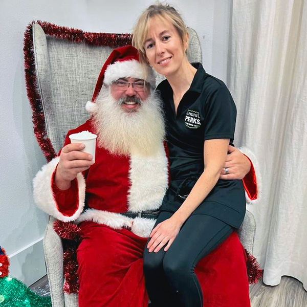 Perkologist Sophia with Santa, who is holding a Pacific Perks hot cocoa