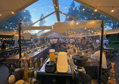 a Pacific Perks Coffee espresso bar mobile café inside a large tent at dusk during a wedding reception