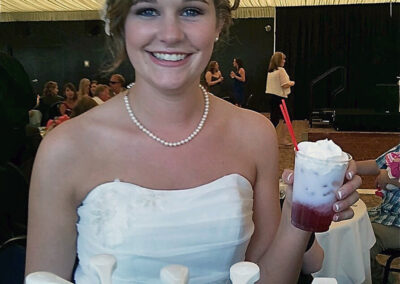 a bride holding a drink from a Pacific Perks Coffee espresso bar mobile café during her wedding