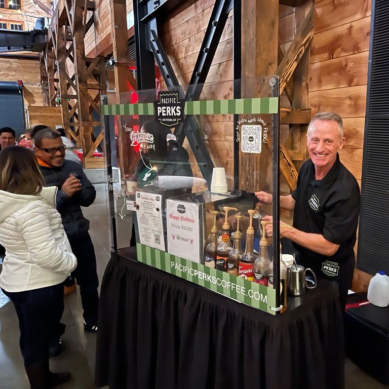 Greg smiling at the camera while working at a Pacific Perks Bar cart