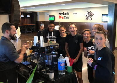 a Perkologist smiling while serving Italian sodas to a group at a graduation party