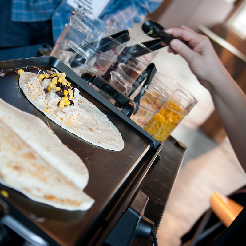 A Pacific Perks perkologist preparing a quesadilla at an event A Pacific Perks perkologist preparing a quesadilla at an event