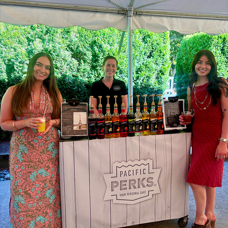 couple and Perkologist smiling at a Pacific Perks mobile Italian Soda bar at a wedding