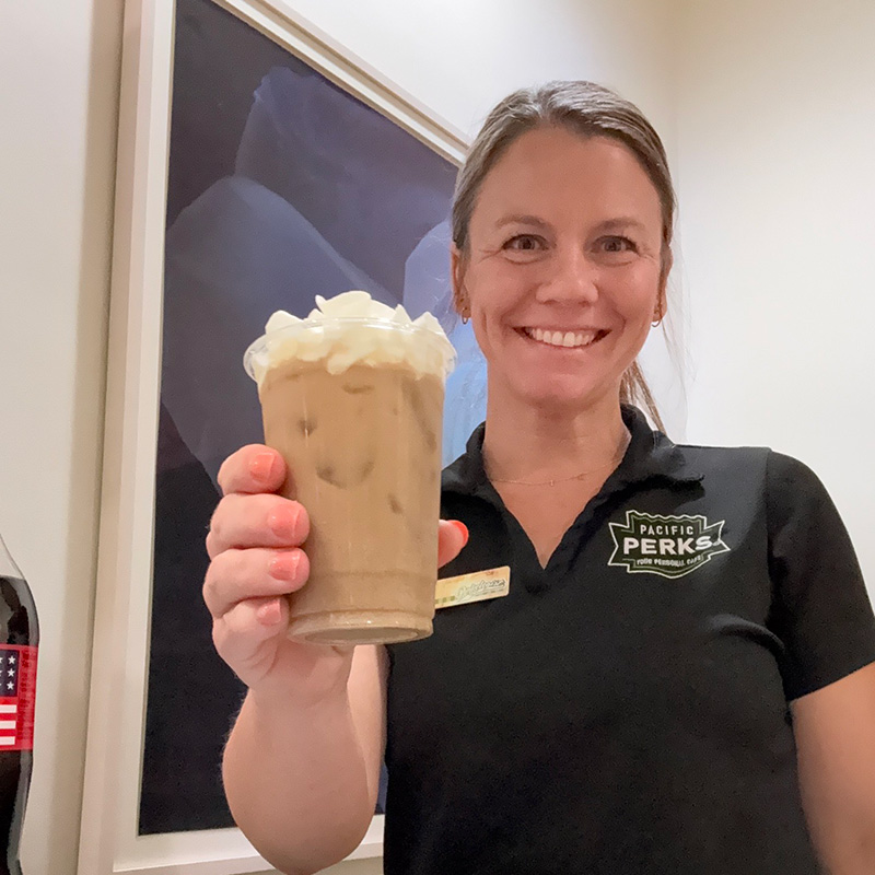 A Pacific Perks Perkologist smiling while holding a drink A Pacific Perks Perkologist smiling while holding a drink